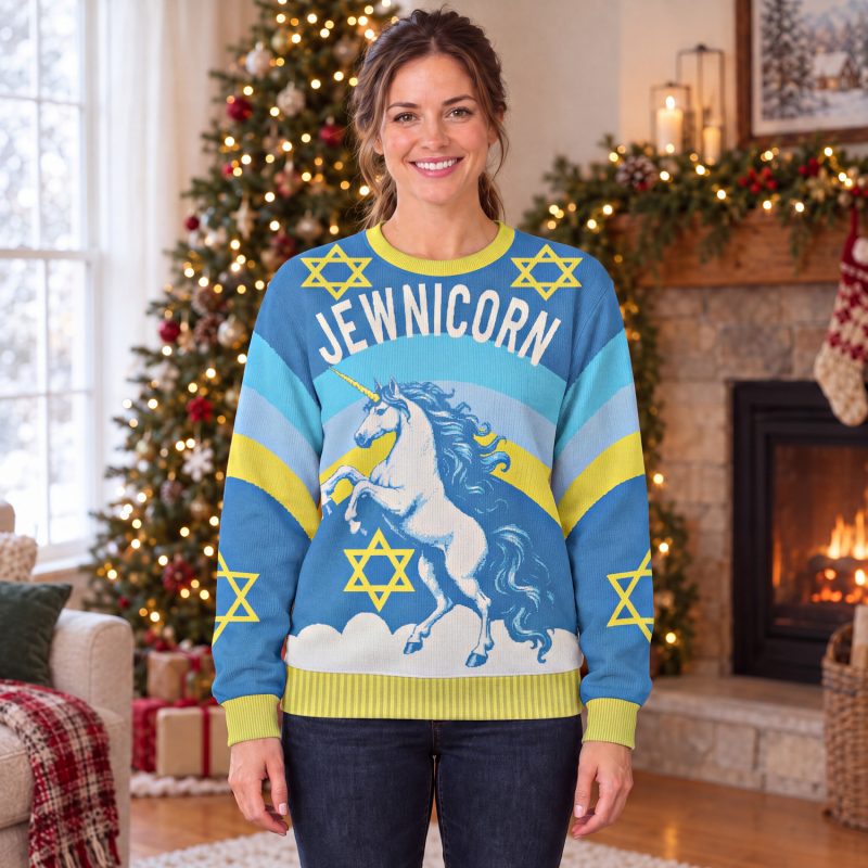 Woman wearing the Jewnicorn ugly Hanukkah sweatshirt with a white unicorn and yellow Stars of David in a festive living room Woman wearing the Jewnicorn ugly Hanukkah sweatshirt with a white unicorn and yellow Stars of David in a festive living room