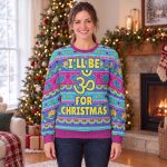 Woman wearing the I’ll Be Om for Christmas yoga ugly Christmas sweatshirt by a Christmas tree Woman wearing the I’ll Be Om for Christmas yoga ugly Christmas sweatshirt by a Christmas tree